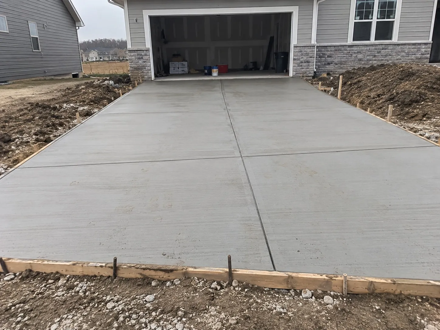 Freshly poured concrete driveway leading to a garage in Hamilton