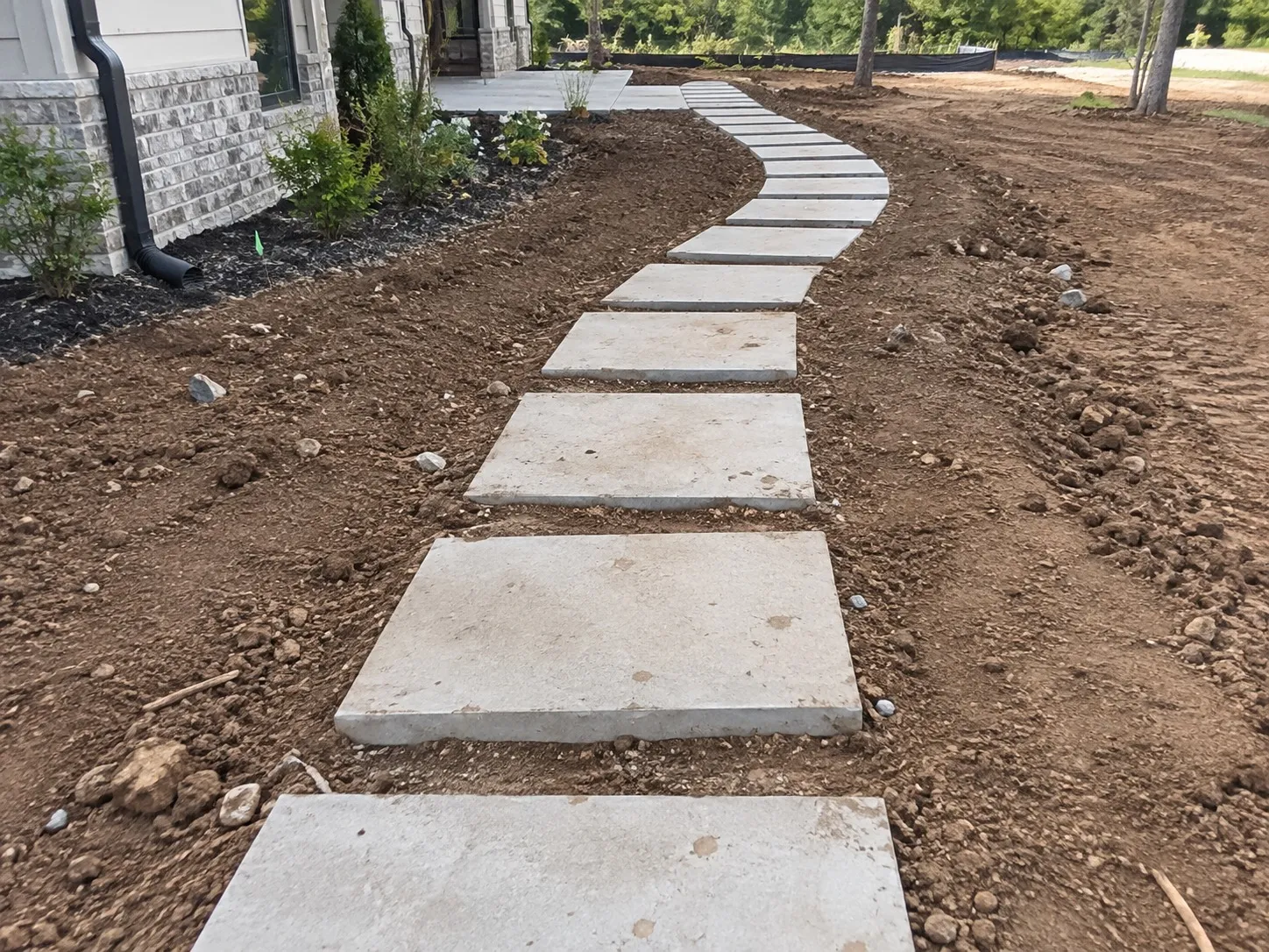 New concrete stepping-stone path curving beside a house in Hamilton