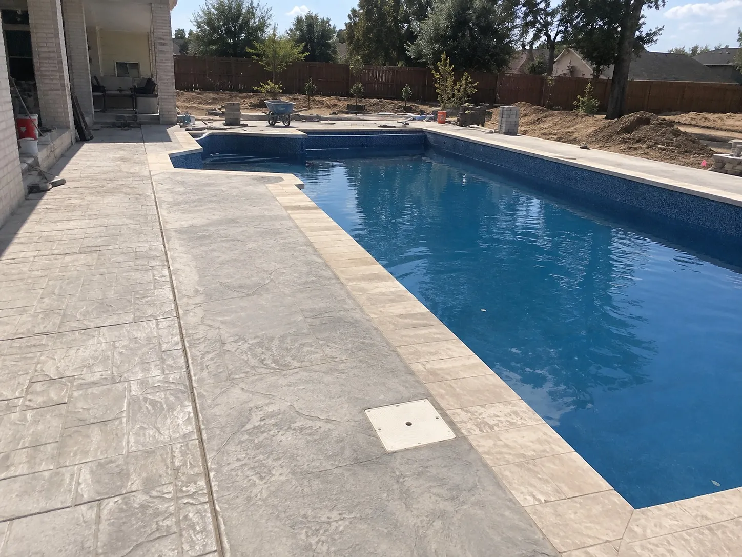 Finished stamped concrete surround around an inground pool in Hamilton