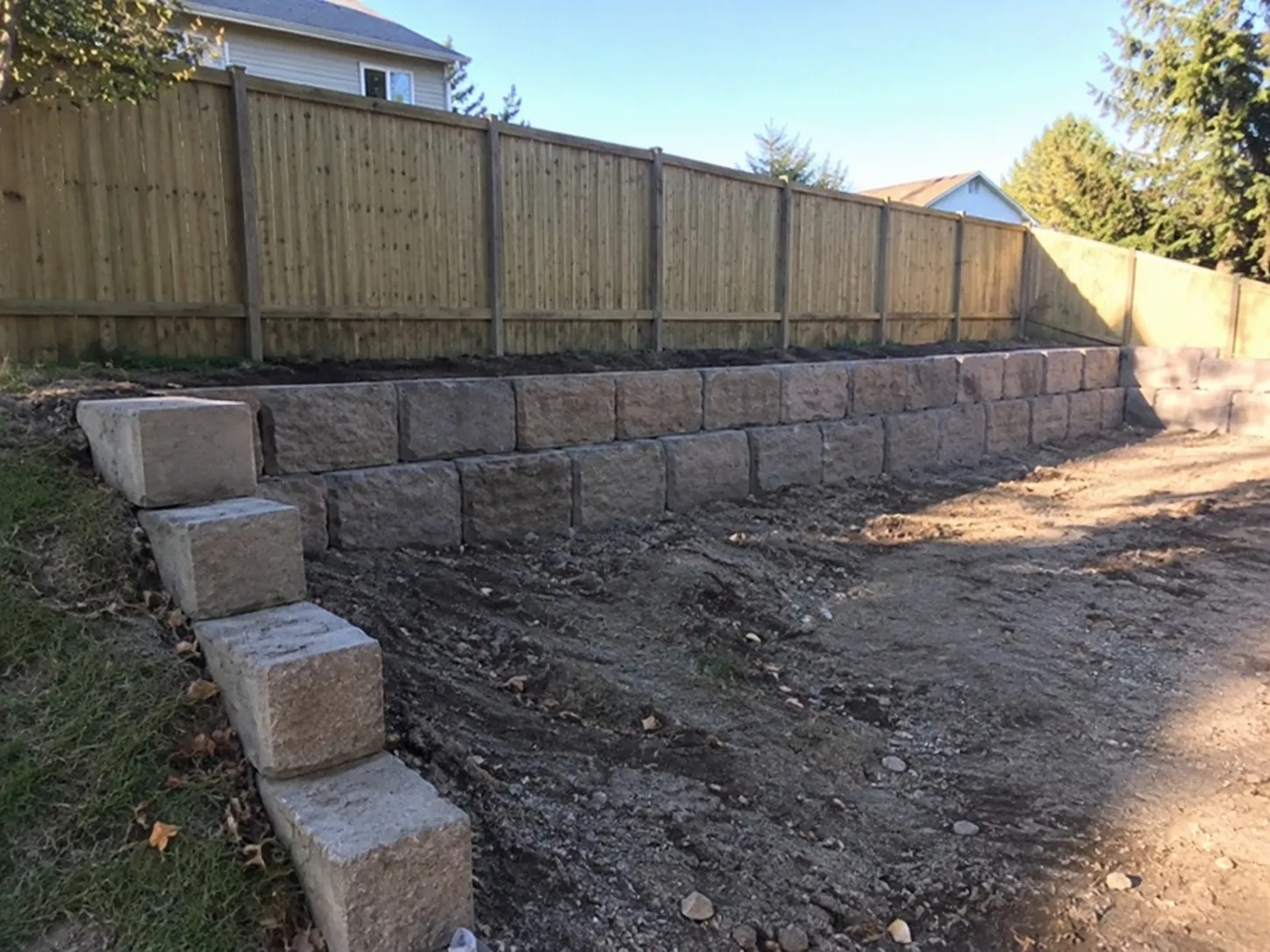 New concrete block retaining wall with a stepped end along a Hamilton section