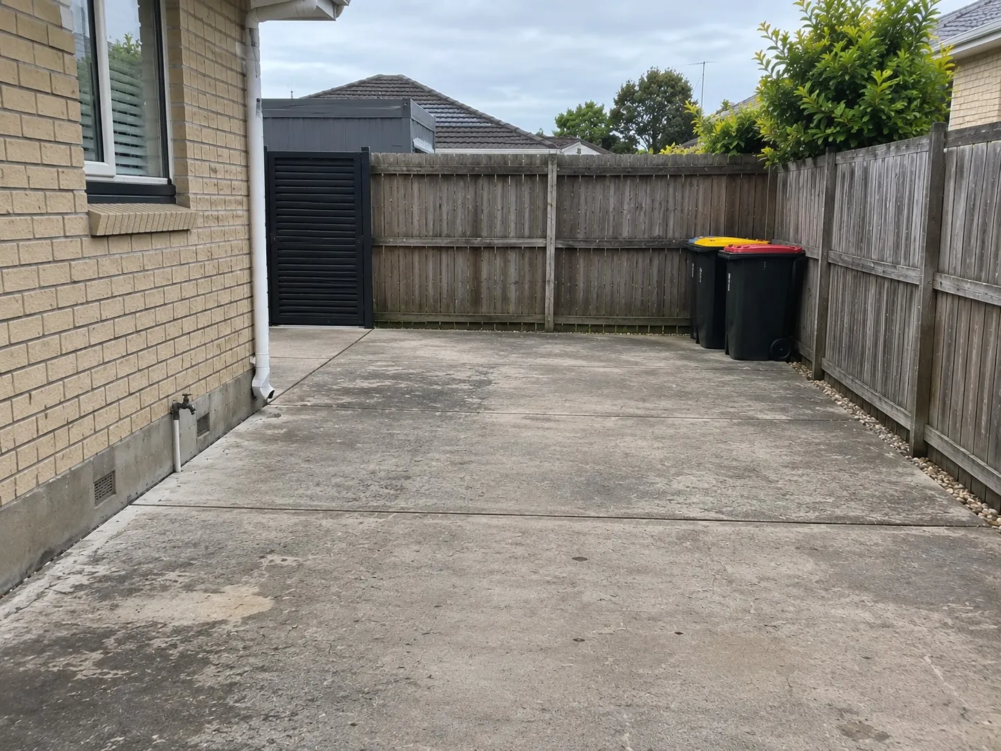 Concrete hardstand and parking area beside a brick home in Hamilton